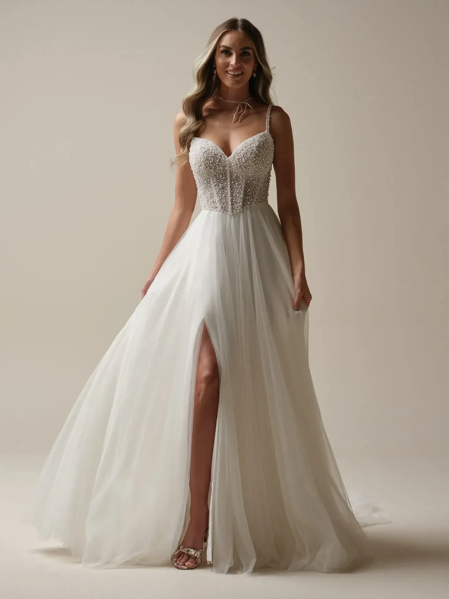 model is wearing a sleeveless a-line tulle wedding gown